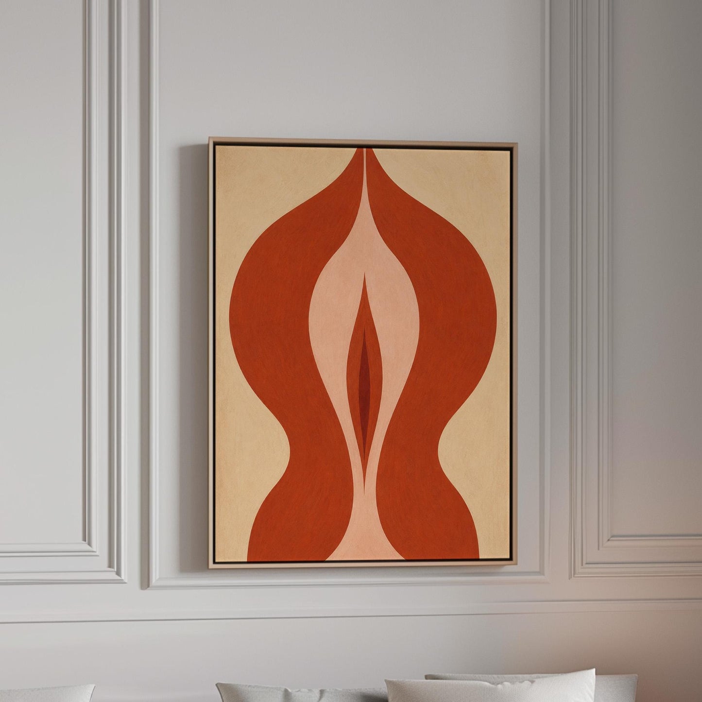 Rust red flame shaped form opening into blush and grey on sand, canvas print in a bright room with natural daylight