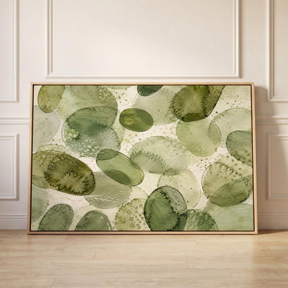Overlapping olive green stone shapes, canvas print held up against a sunlit bedroom wall