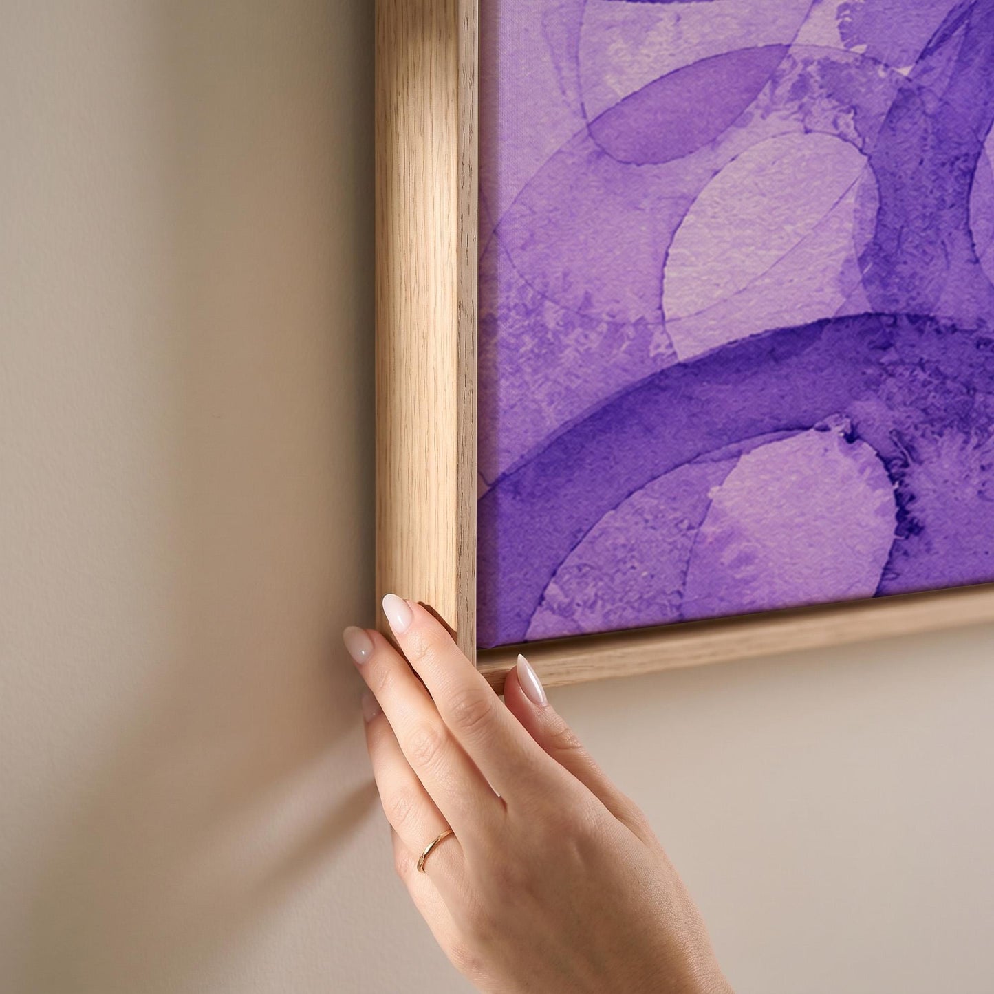 Swirling violet watercolor rings across wide frame, canvas print shown at full size in a light-filled bedroom