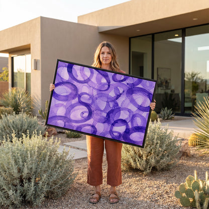 Swirling violet watercolor rings across wide frame, canvas print on a quiet wall in a considered interior