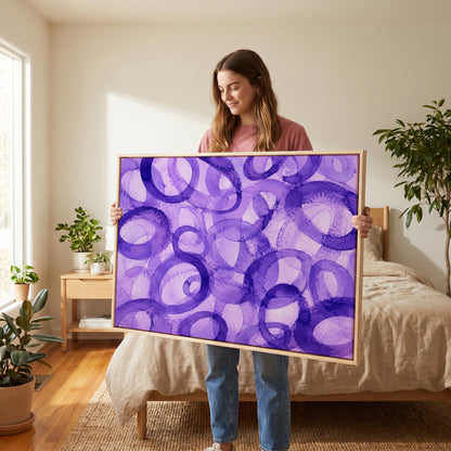 Swirling violet watercolor rings across wide frame, canvas print shown to scale in a furnished room