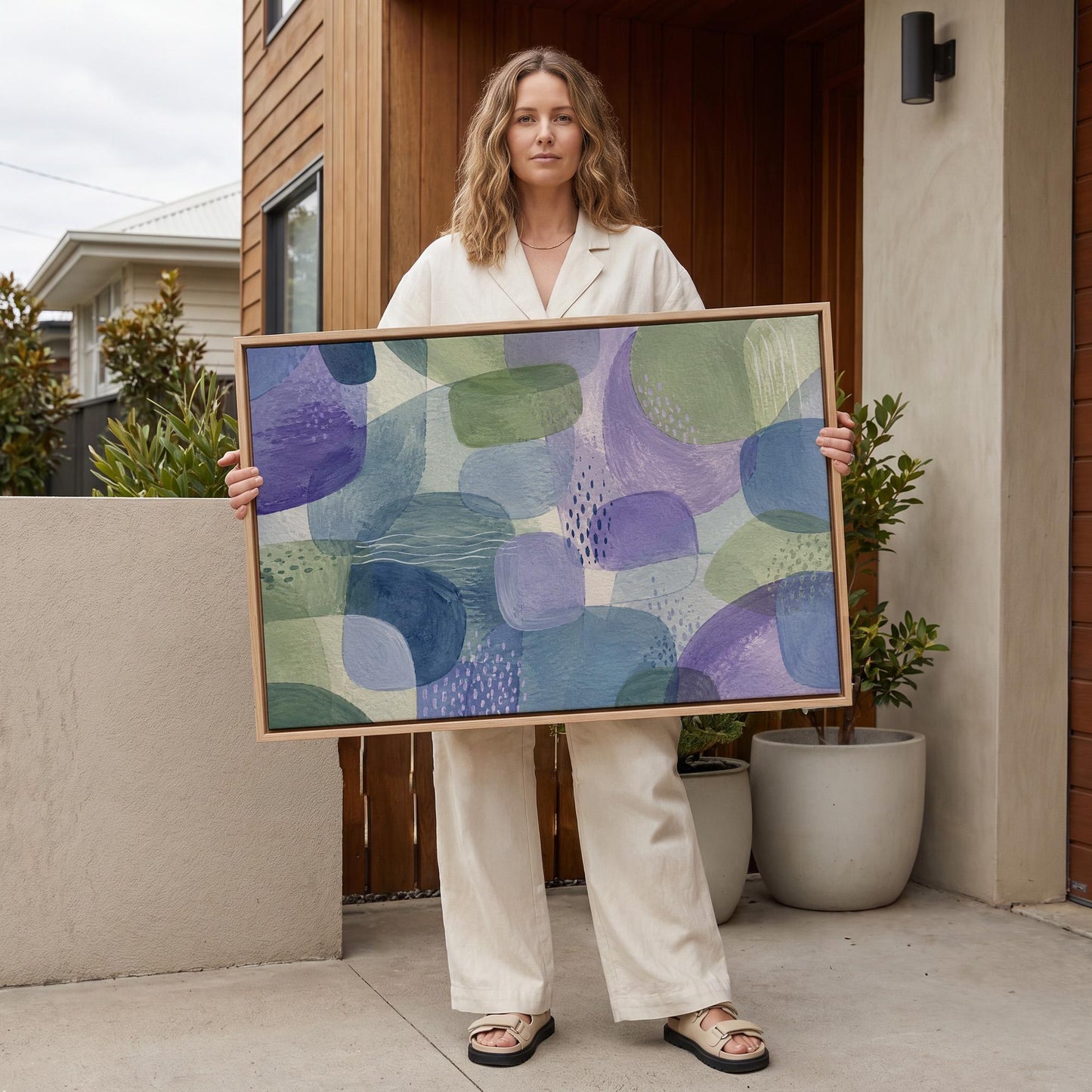 Soft muted shapes in dusty plum and sage, canvas print shown to scale in a furnished room