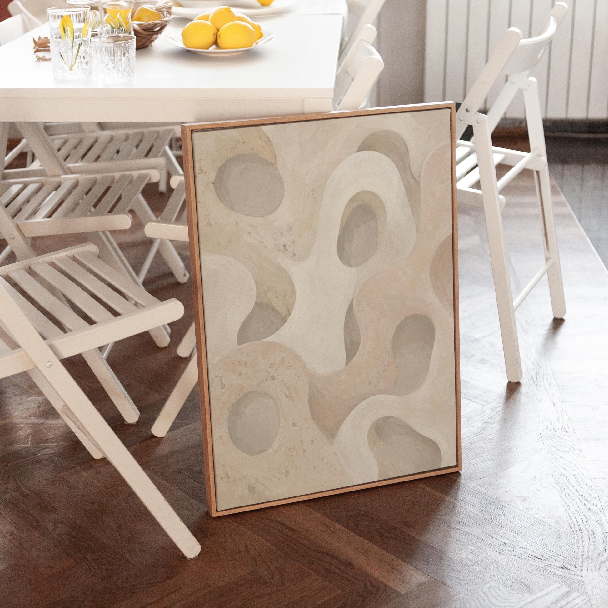 Soft organic flowing shapes in cream and light beige, canvas print hanging in a calm, modern living space