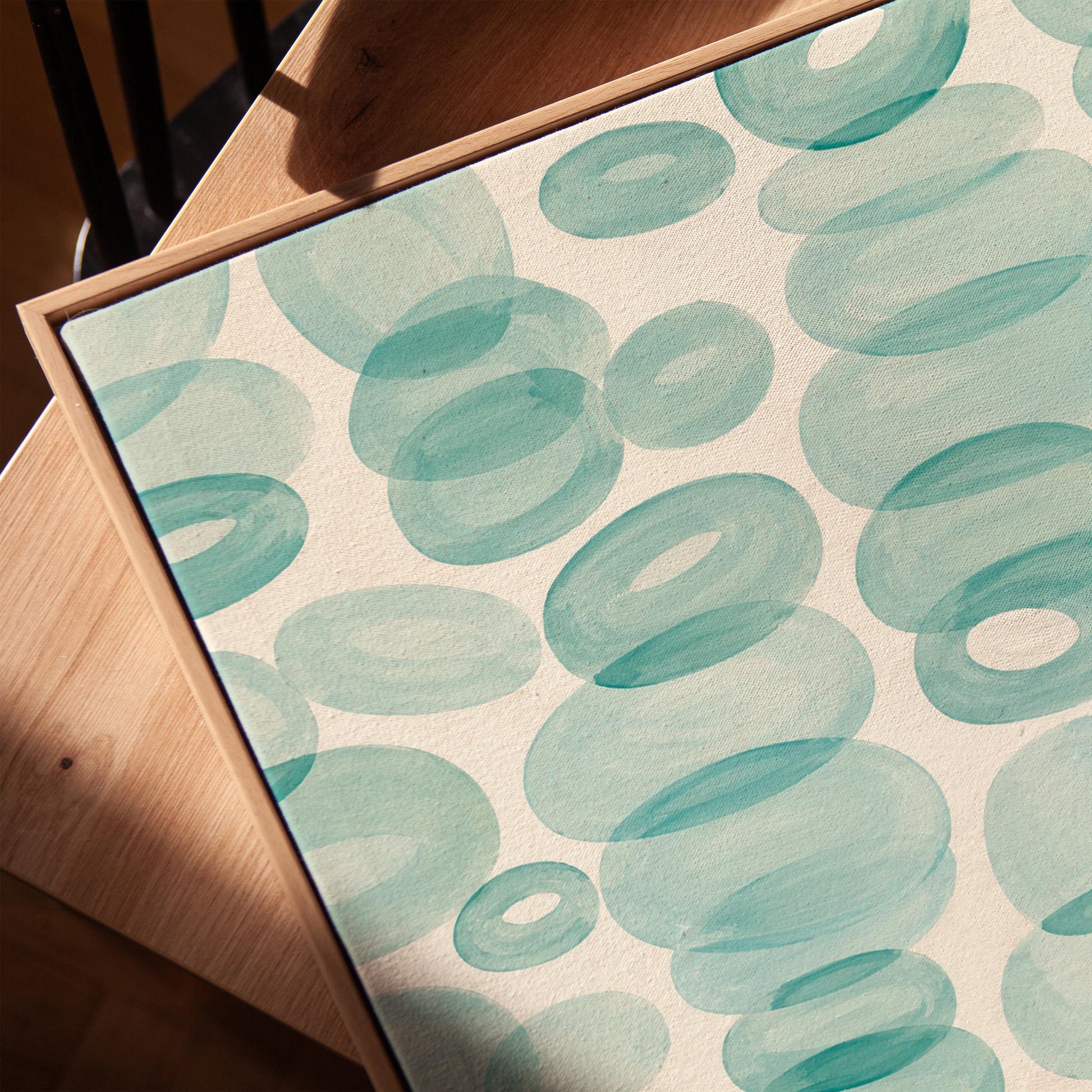 Watercolor rings and ovals in aqua and teal like sea glass, canvas print in a warm, minimally styled interior