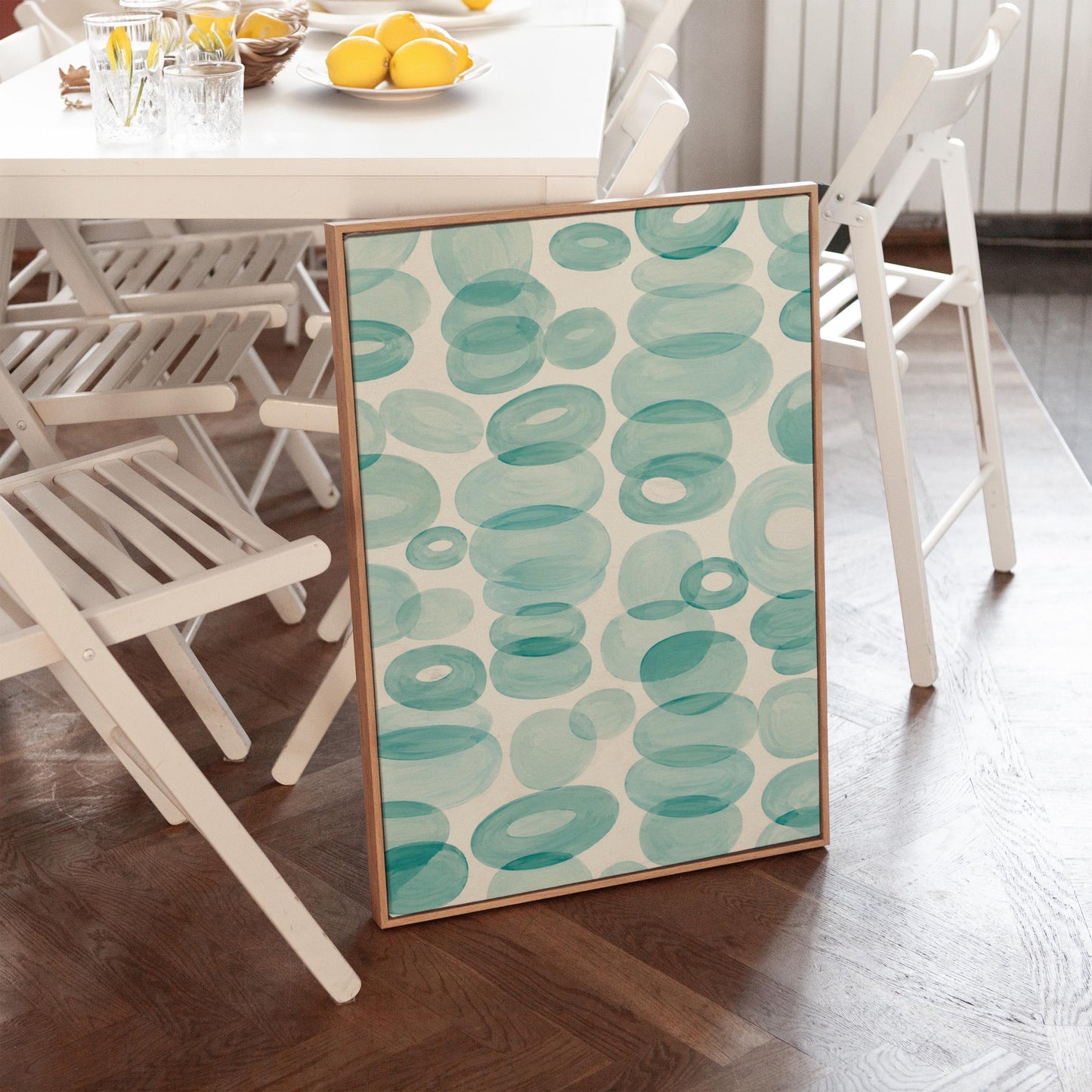 Watercolor rings and ovals in aqua and teal like sea glass, canvas print hanging in a calm, modern living space
