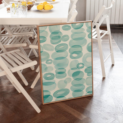 Watercolor rings and ovals in aqua and teal like sea glass, canvas print hanging in a calm, modern living space