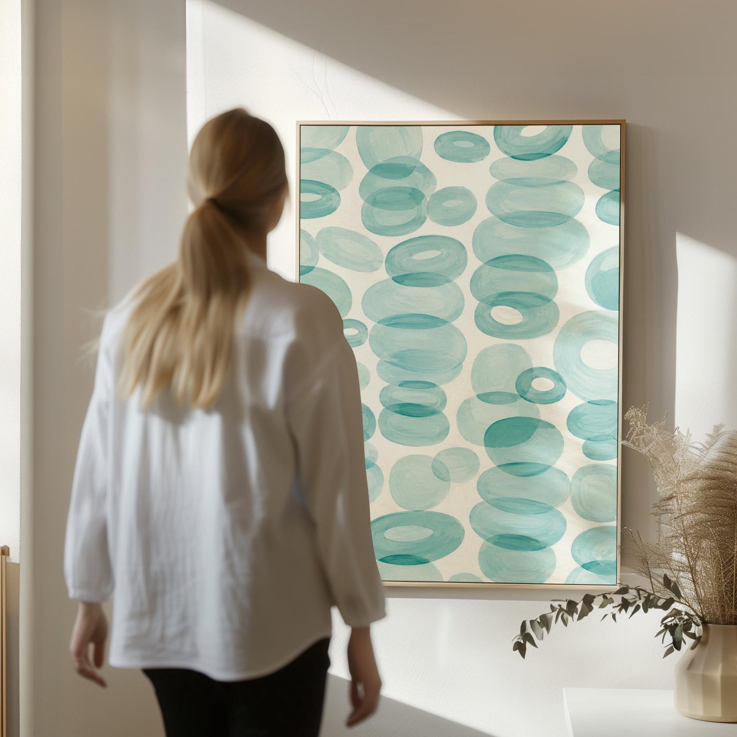 Watercolor rings and ovals in aqua and teal like sea glass, canvas print styled against a soft white wall
