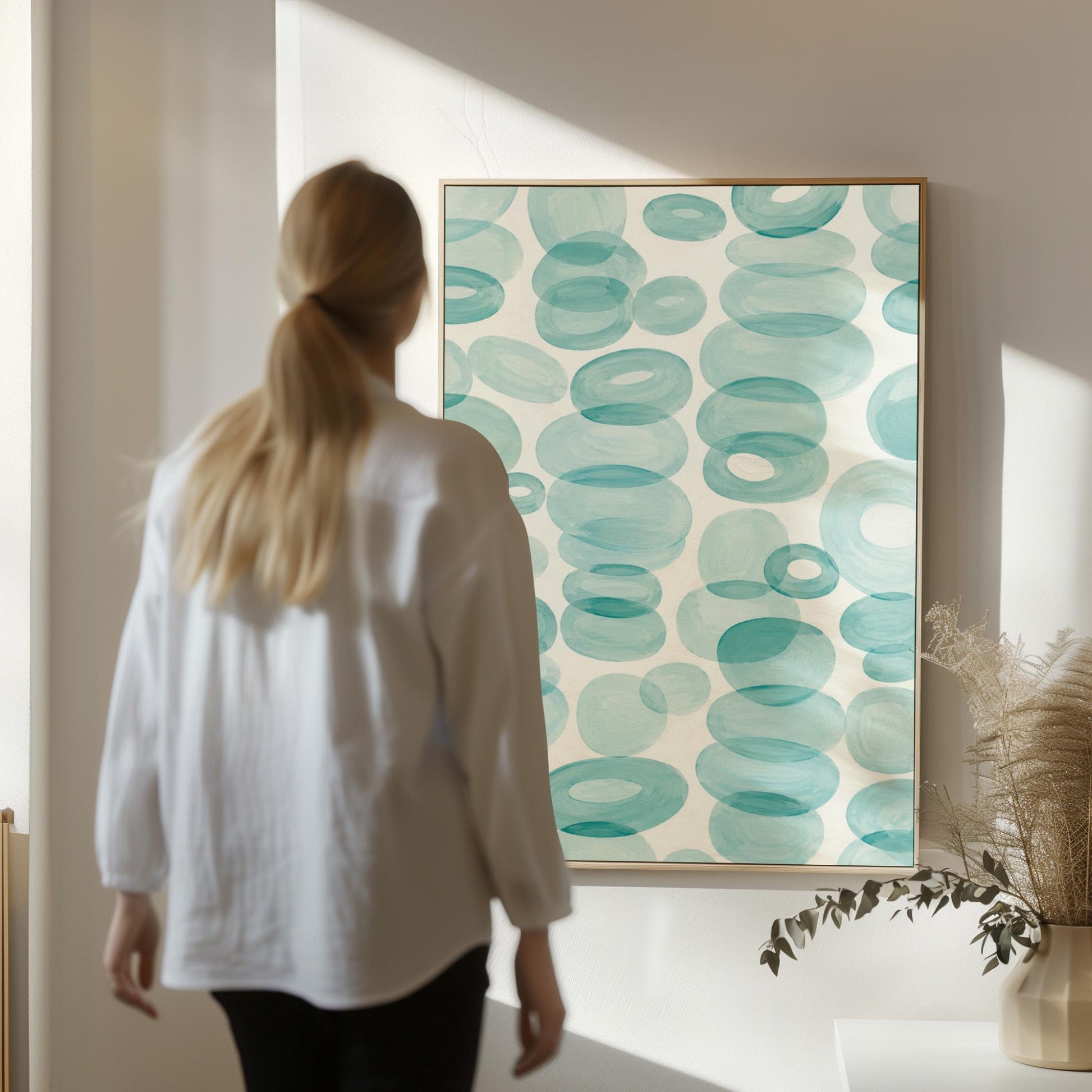 Watercolor rings and ovals in aqua and teal like sea glass, canvas print styled against a soft white wall