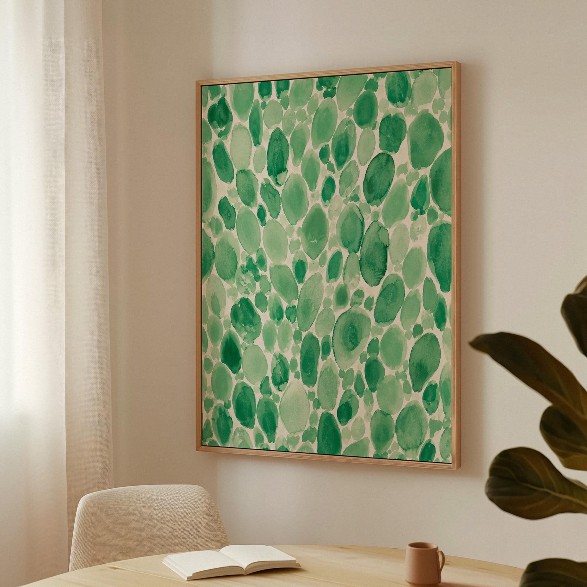 Dense watercolor pebble shapes in mint to emerald green, canvas print hanging in a calm, modern living space