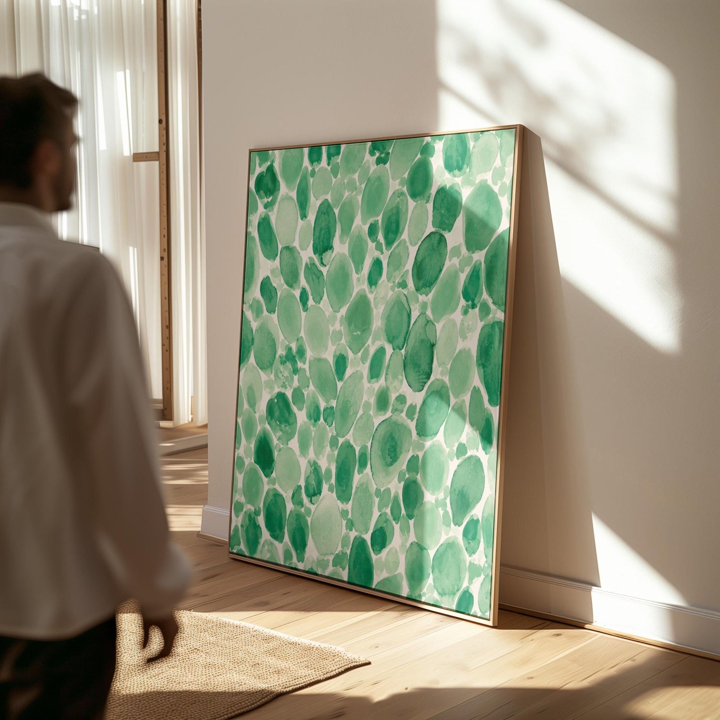 Dense watercolor pebble shapes in mint to emerald green, canvas print shown to scale in a furnished room