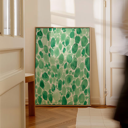 Dense watercolor pebble shapes in mint to emerald green, canvas print shown in a sunlit, contemporary room
