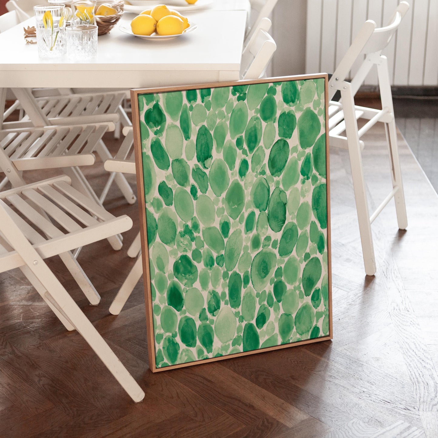 Dense watercolor pebble shapes in mint to emerald green, canvas print seen in a warm interior with natural light