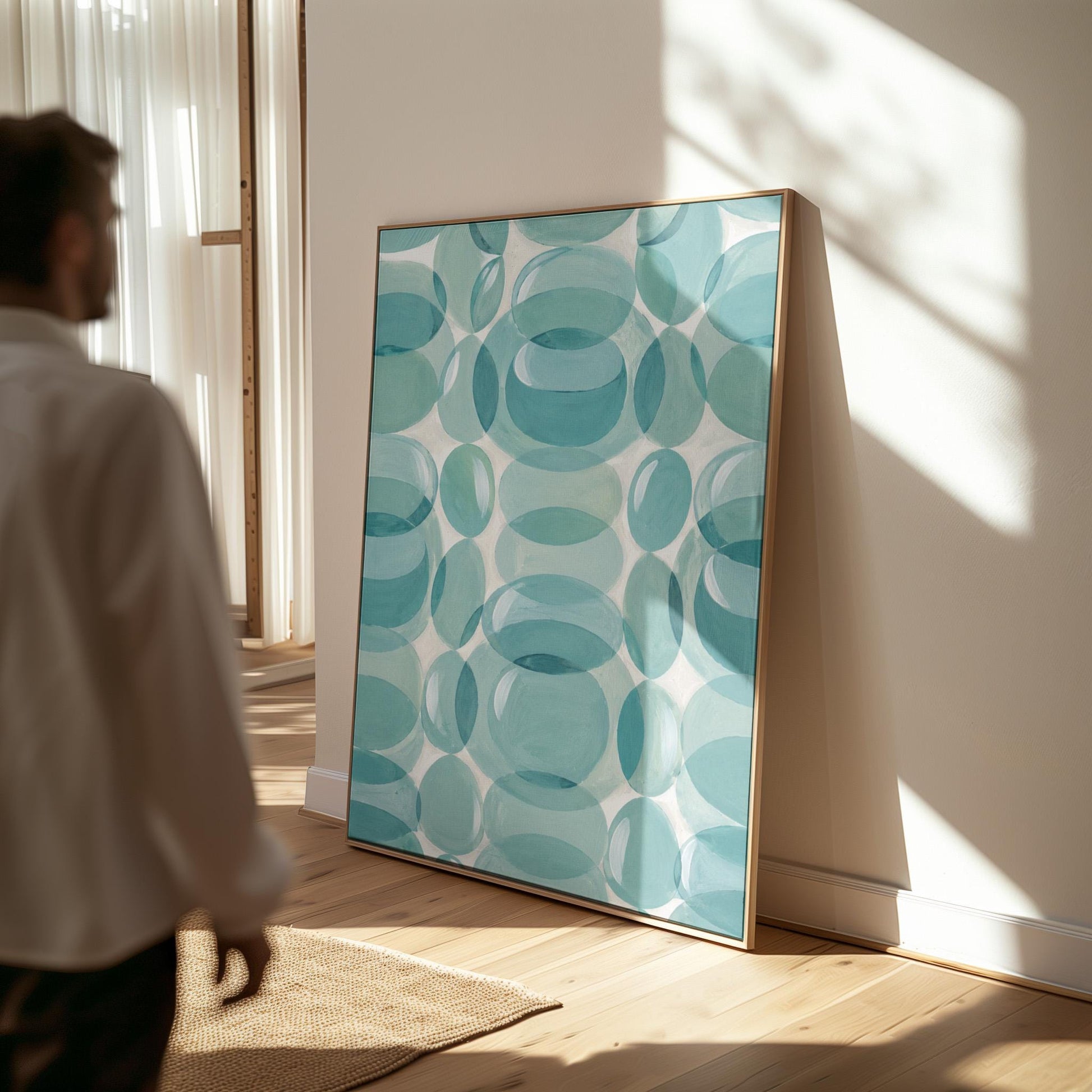 Overlapping translucent circles in teal and aqua tones, canvas print displayed on a neutral wall in a styled interior
