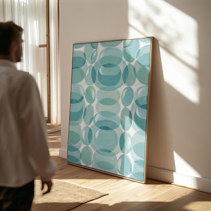 Overlapping translucent circles in teal and aqua tones, canvas print displayed on a neutral wall in a styled interior