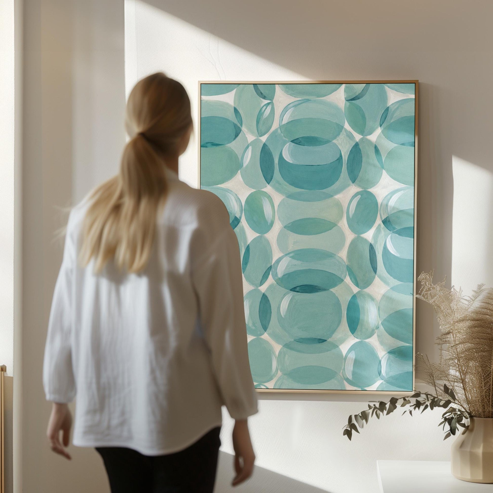 Overlapping translucent circles in teal and aqua tones, canvas wall art styled against a soft white wall