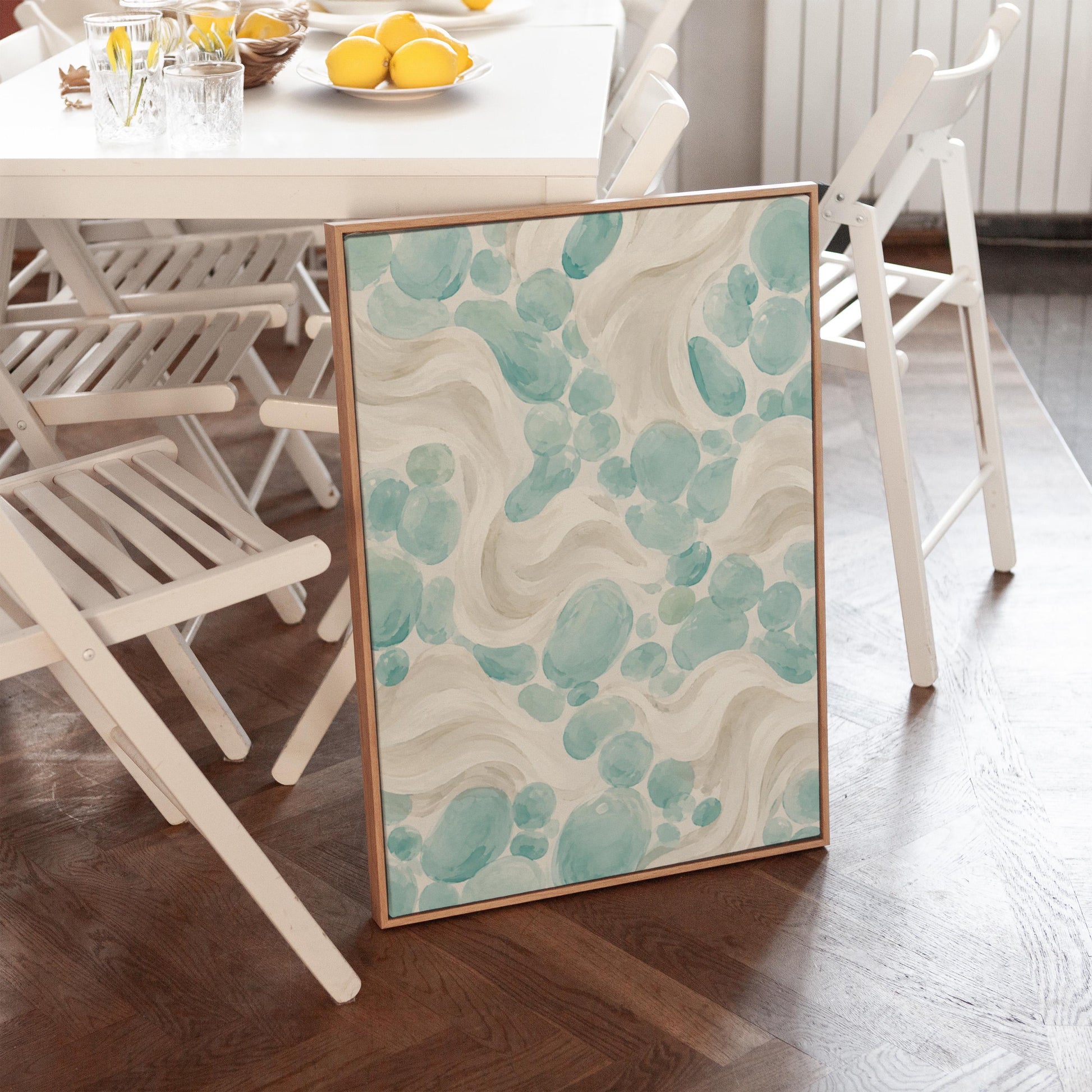 Aqua pebble shapes drifting among soft cream waves, canvas wall art styled against a soft white wall