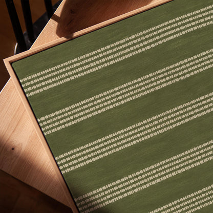 Olive green field with thin cream pinstripe rows, canvas print in a warm, minimally styled interior