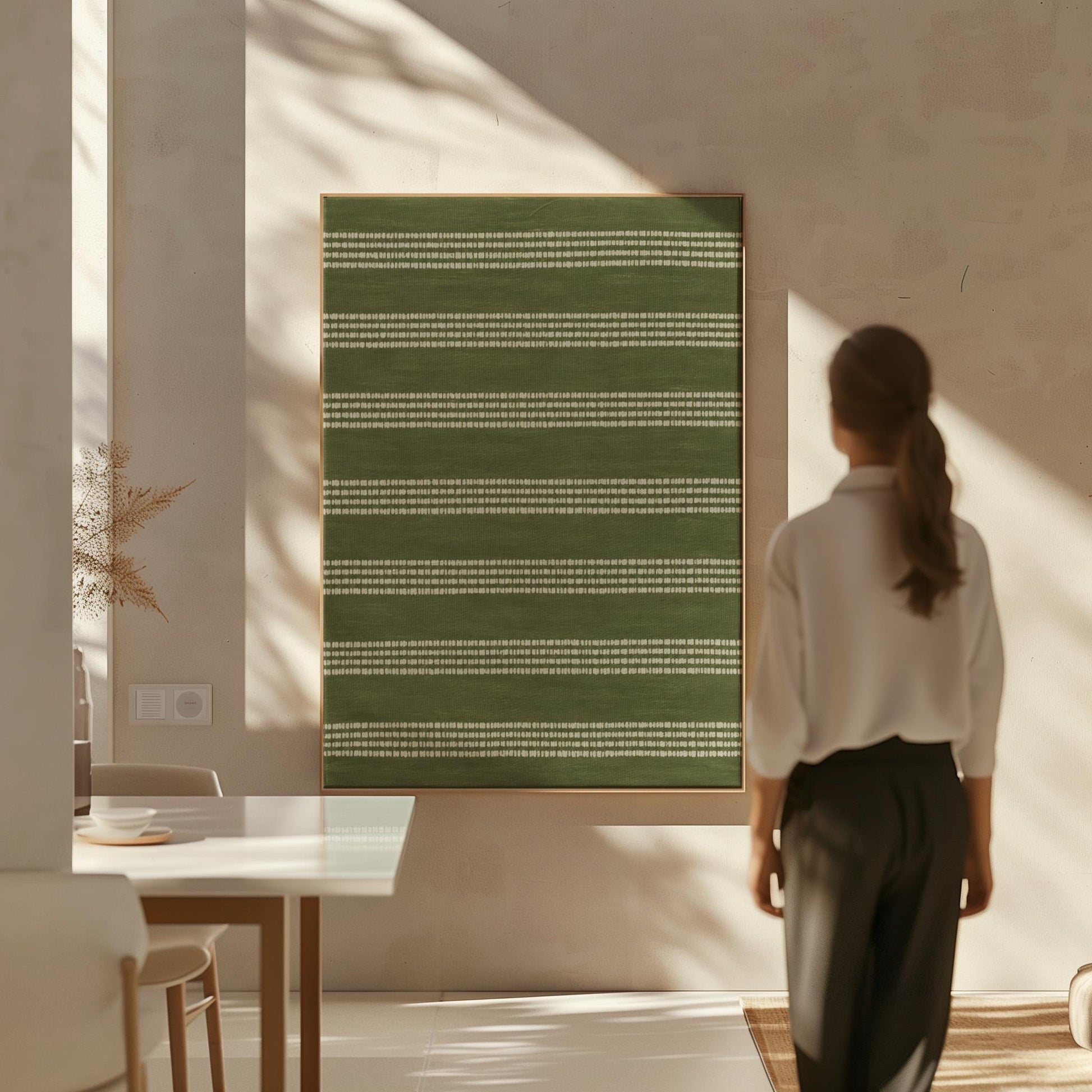 Olive green field with thin cream pinstripe rows, canvas print hanging in a calm, modern living space