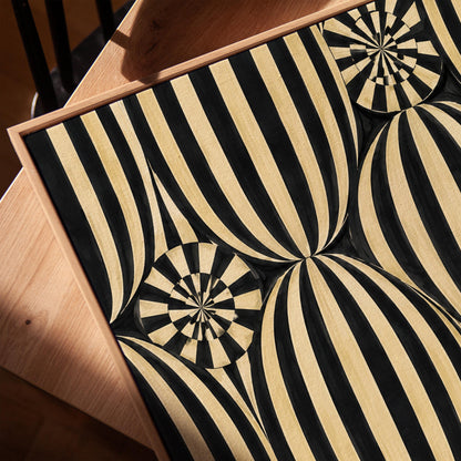 Optical illusion of striped spheres in black and cream, canvas print in a warm, minimally styled interior