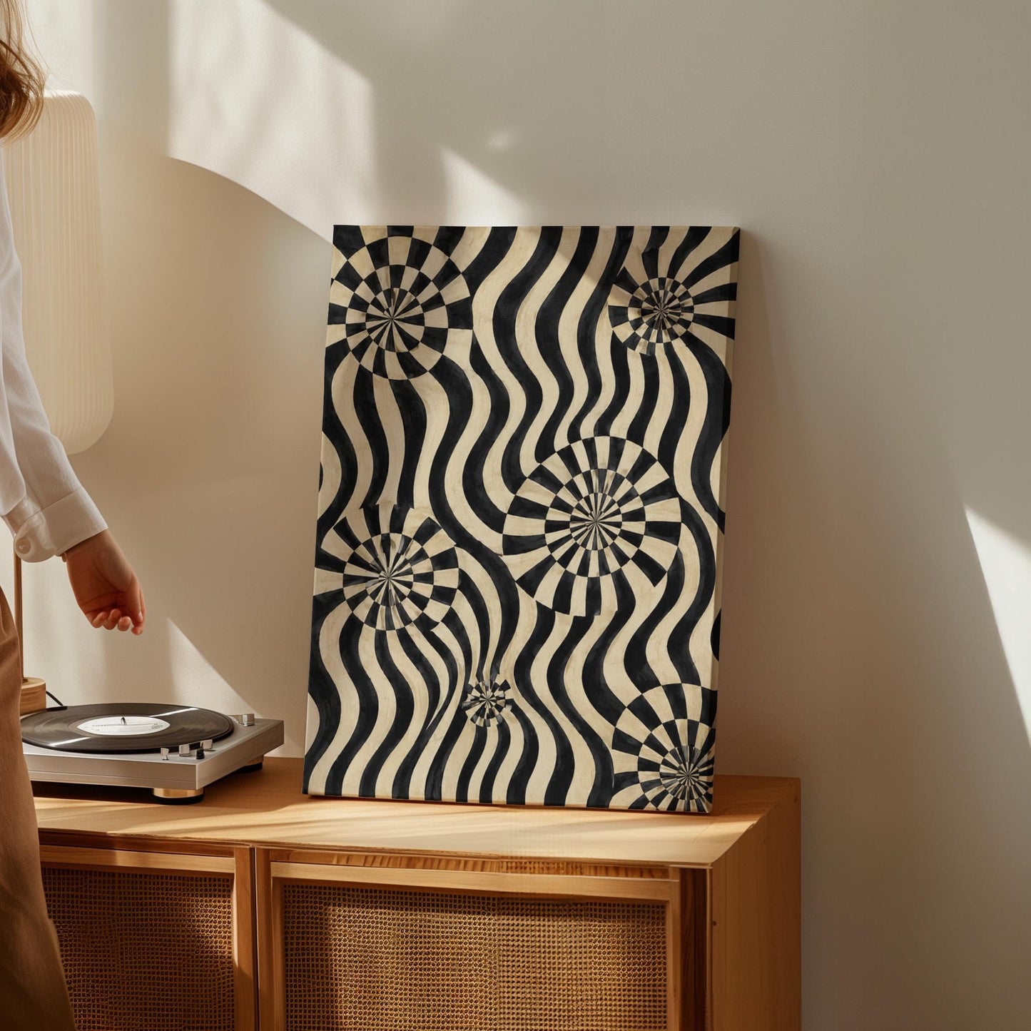 Swirling wavy stripes with spiral discs in black and ivory, canvas print seen in a warm interior with natural light