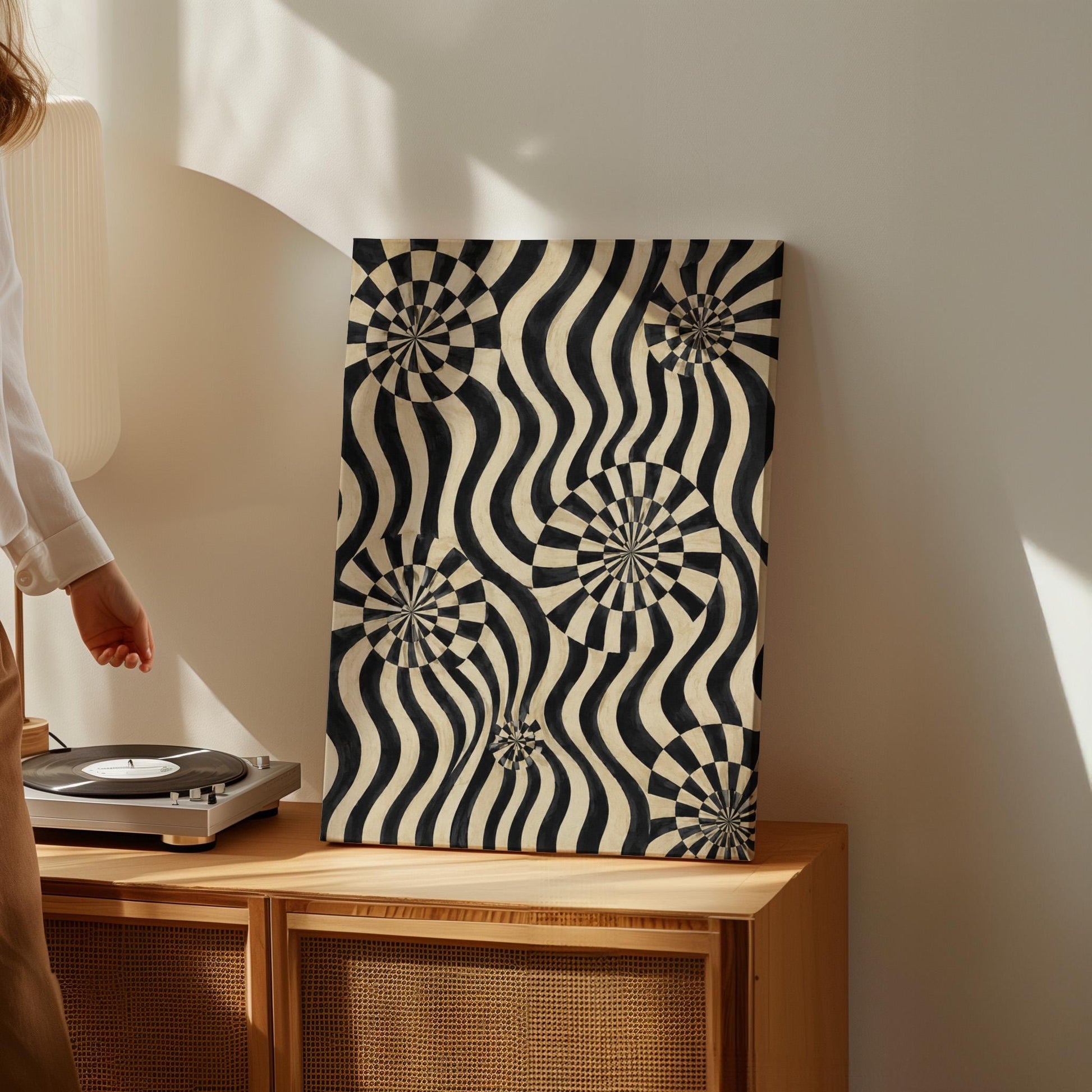 Swirling wavy stripes with spiral discs in black and ivory, canvas print seen in a warm interior with natural light