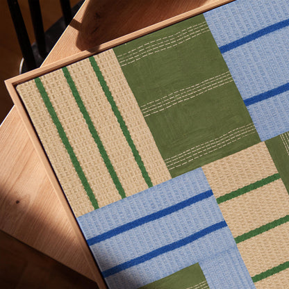 Patchwork of sage green fields with periwinkle blue bands, canvas print in a warm, minimally styled interior