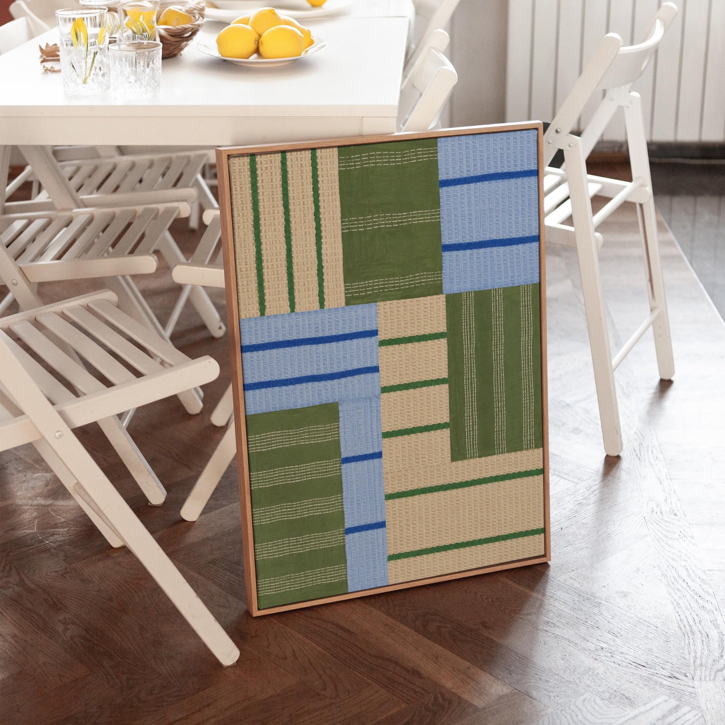 Patchwork of sage green fields with periwinkle blue bands, canvas wall art presented in a light, minimal room