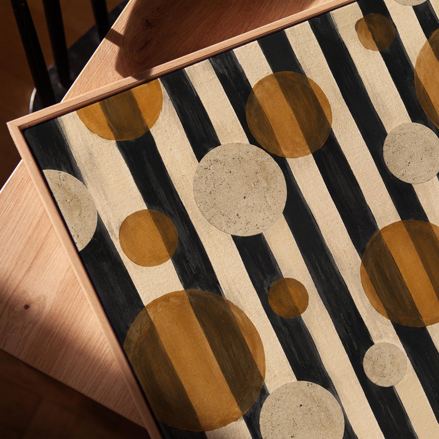Amber and cream circles scattered over black vertical stripes, canvas print in a warm, minimally styled interior