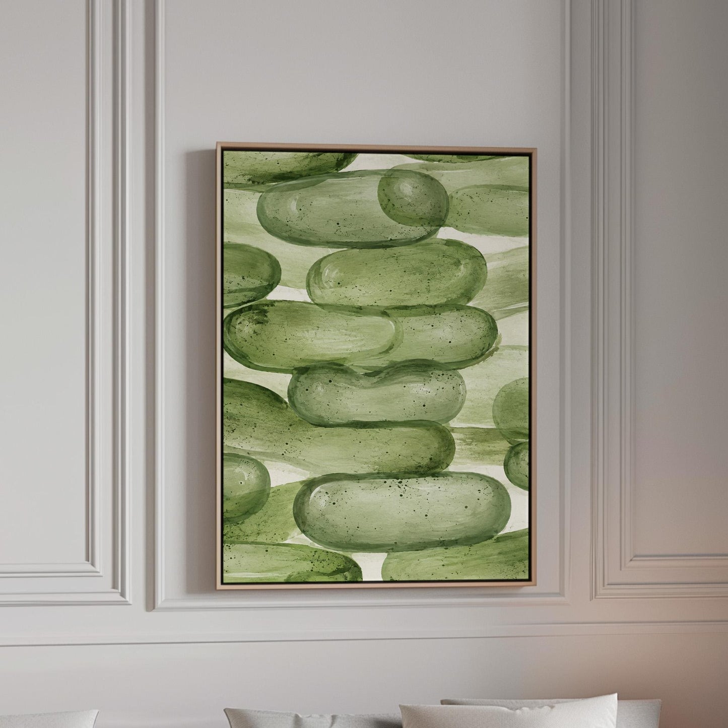 Stacked smooth green stones painted in watercolor, canvas print in a bright room with natural daylight