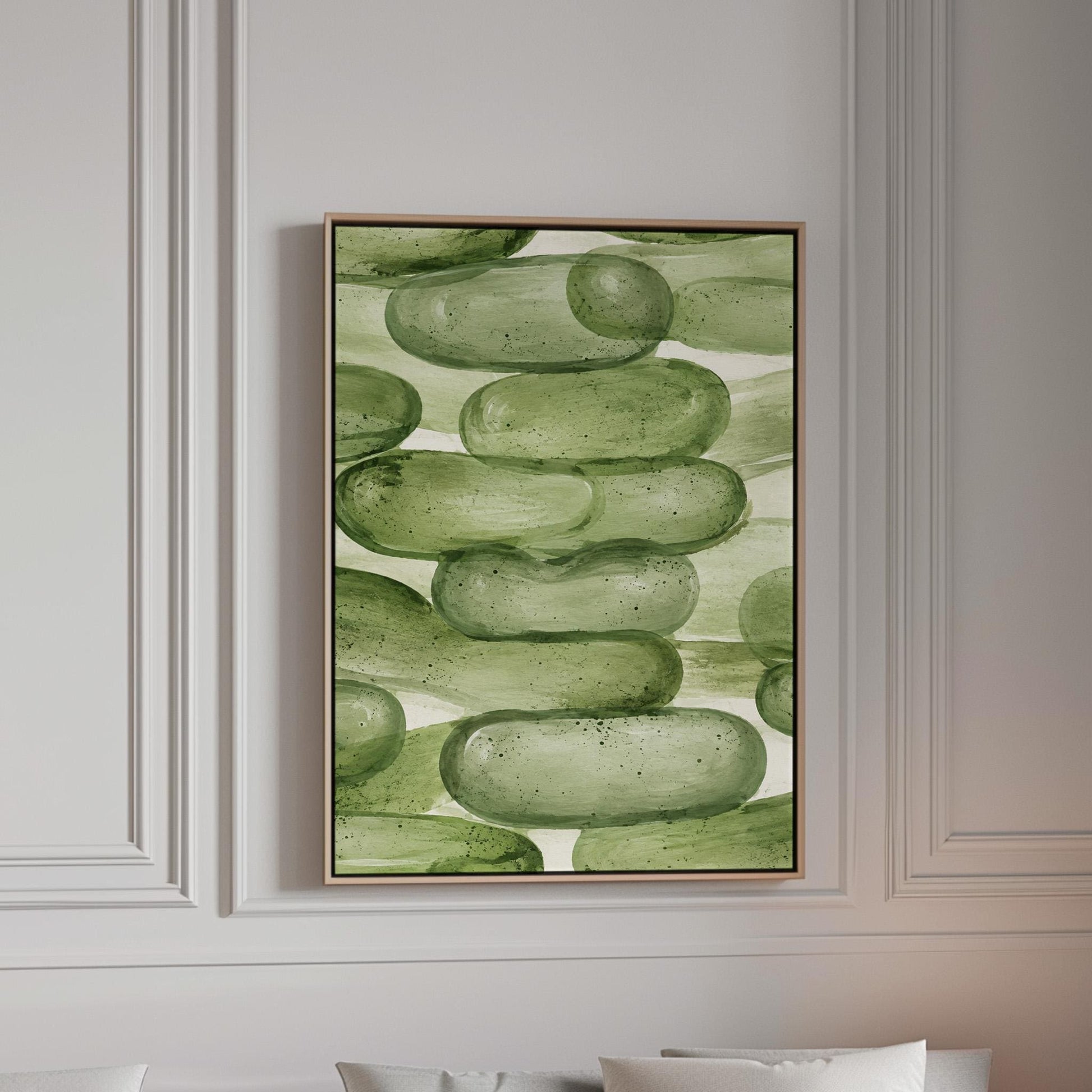 Stacked smooth green stones painted in watercolor, canvas print in a bright room with natural daylight