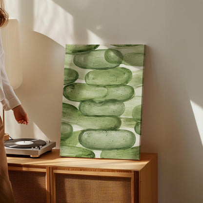 Stacked smooth green stones painted in watercolor, canvas print shown to scale in a furnished room