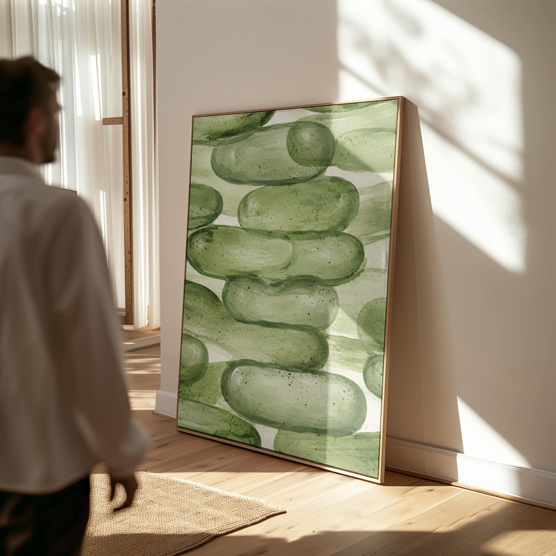 Stacked smooth green stones painted in watercolor, canvas print shown in a sunlit, contemporary room