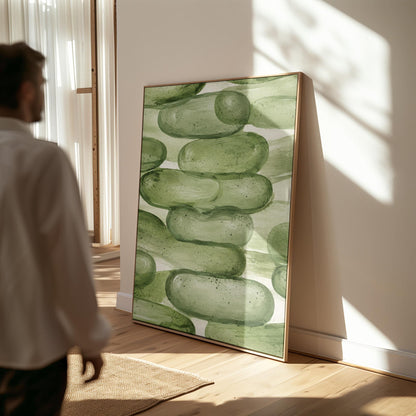 Stacked smooth green stones painted in watercolor, canvas print shown in a sunlit, contemporary room