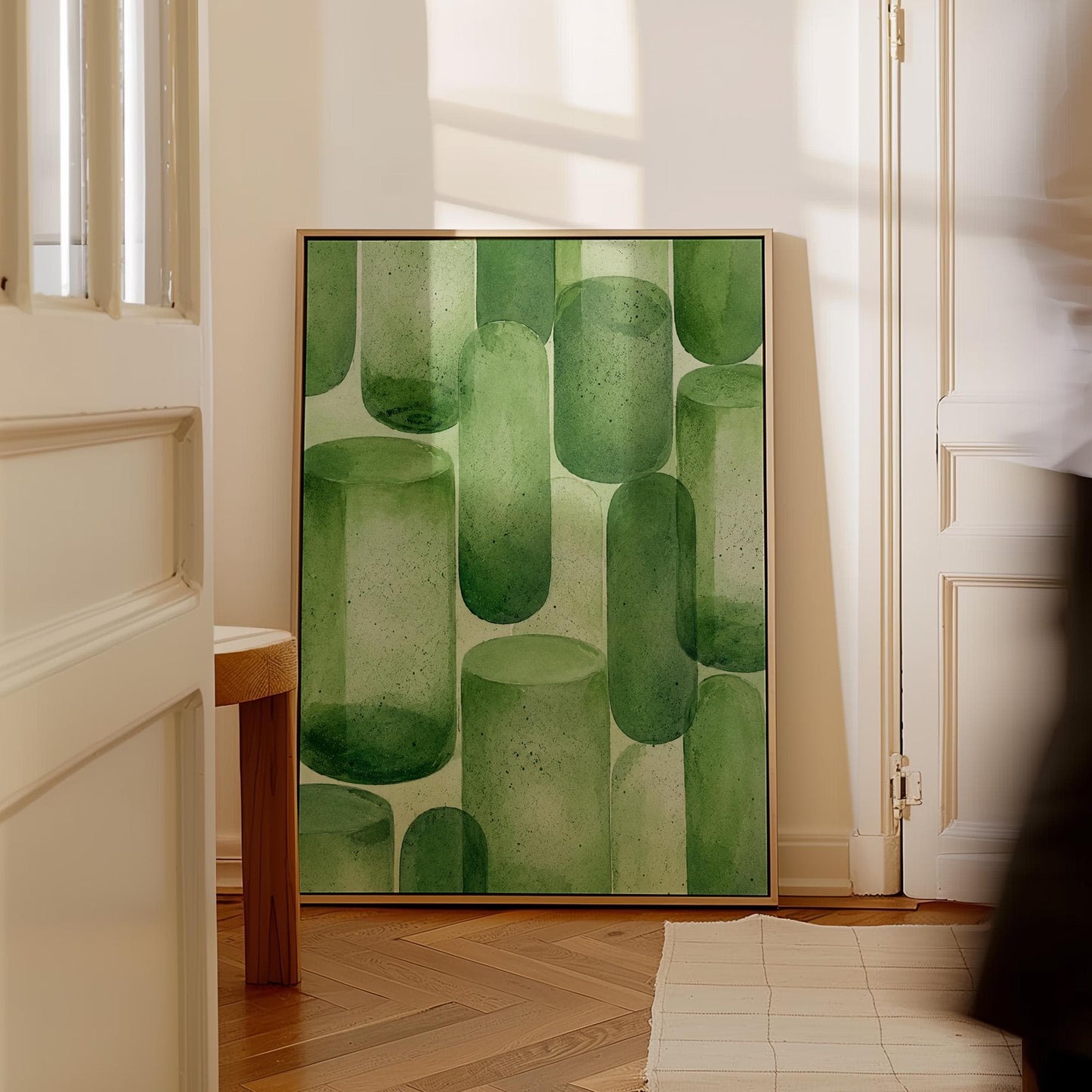 Rounded capsule shapes in layered watercolor greens, canvas print hanging in a calm, modern living space