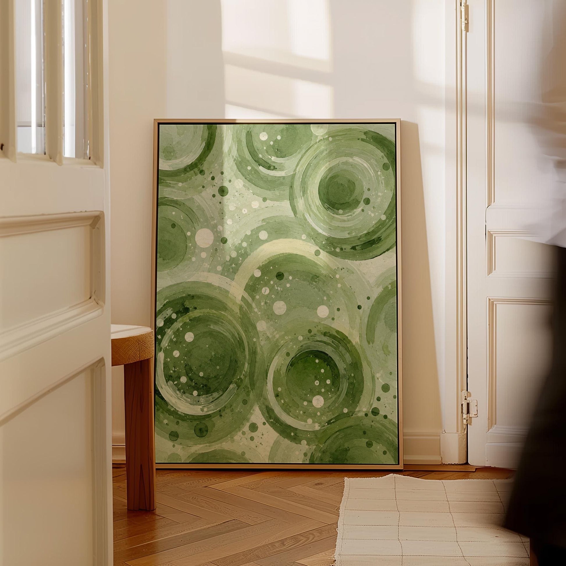 Rings and bubbles swirling in sage green watercolor, canvas print presented in a light, minimal room