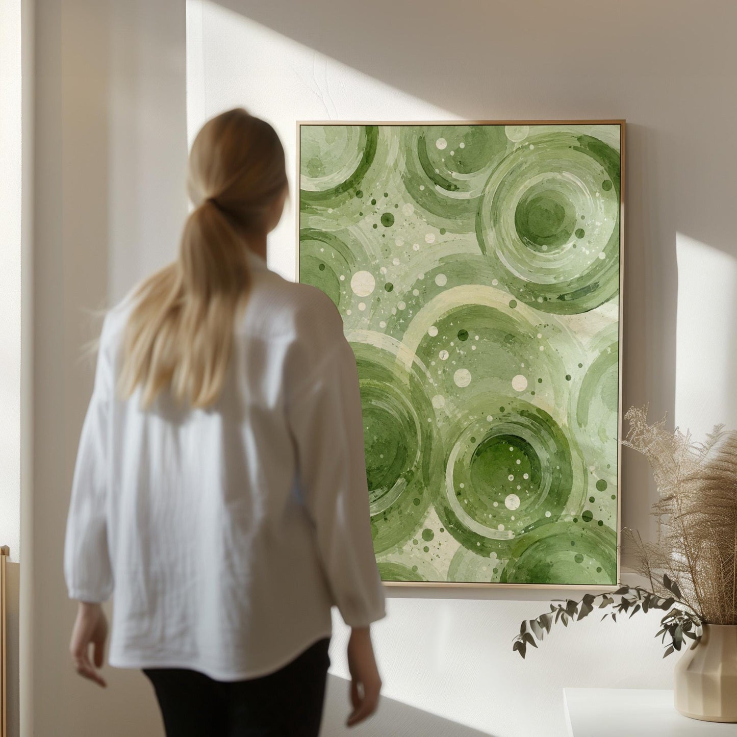 Rings and bubbles swirling in sage green watercolor, canvas print displayed on a neutral wall in a styled interior