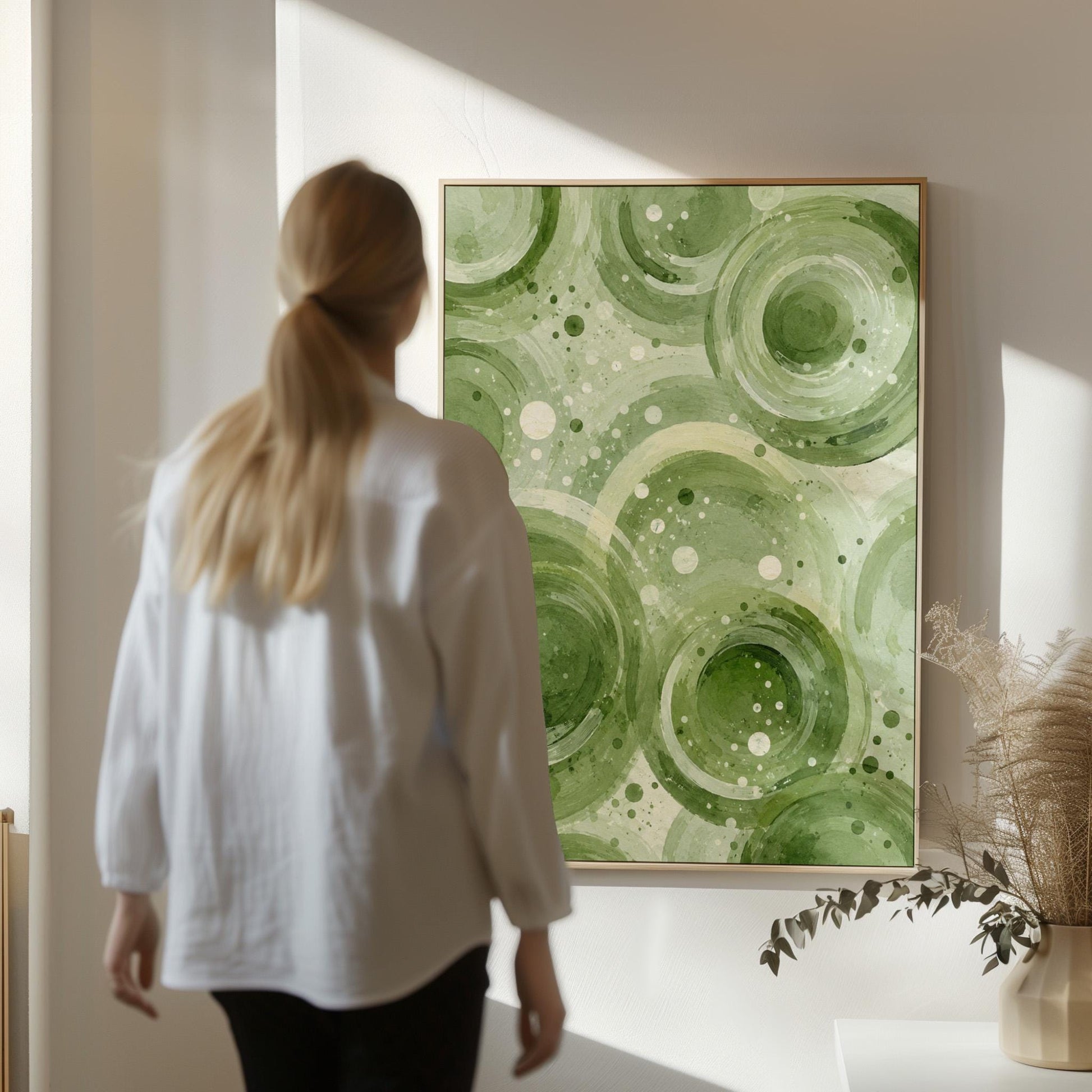 Rings and bubbles swirling in sage green watercolor, canvas print displayed on a neutral wall in a styled interior