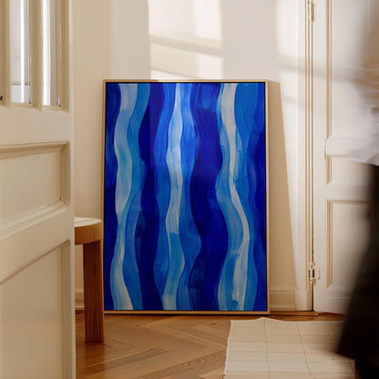 Vertical flowing ribbons in cobalt and light blue, canvas print displayed on a neutral wall in a styled interior