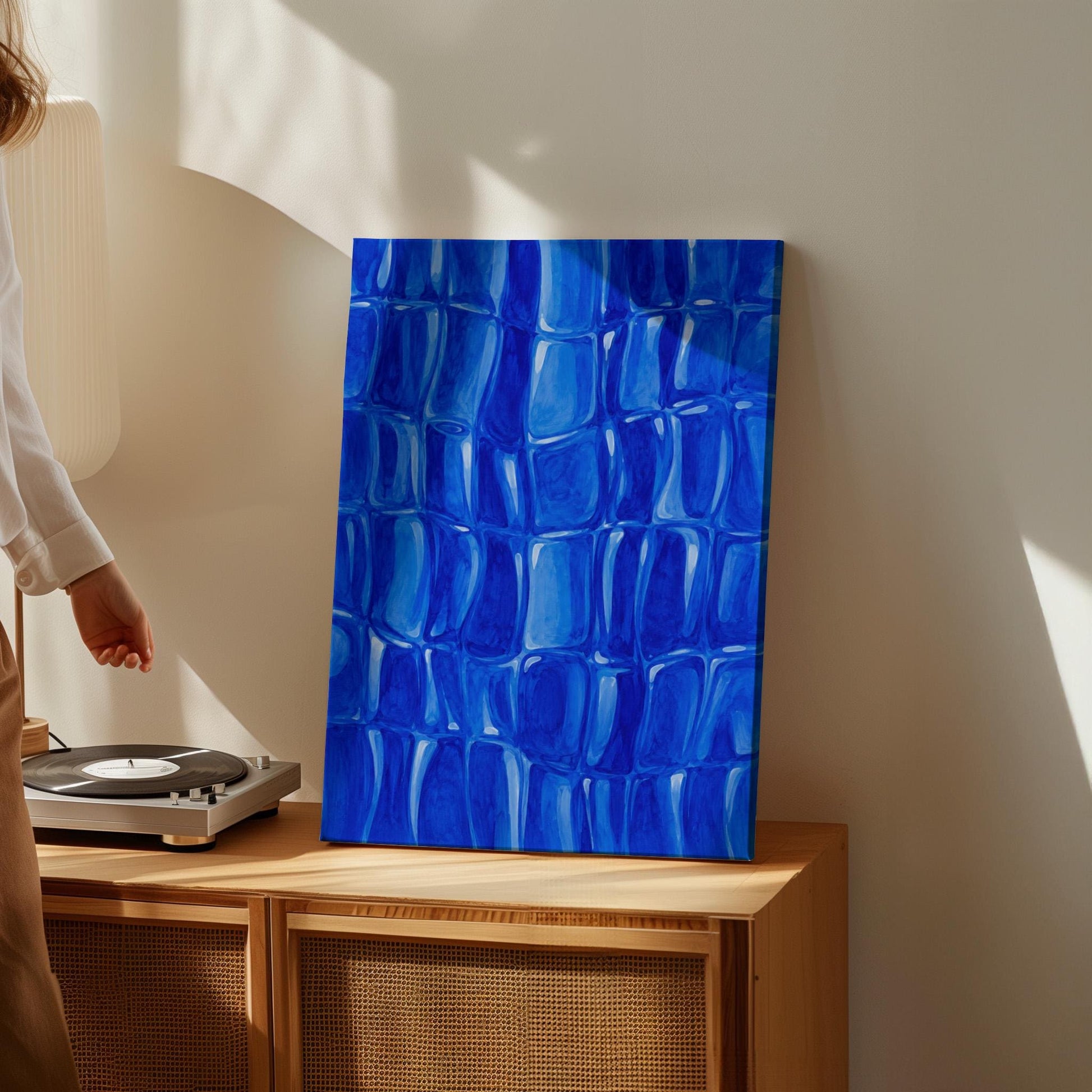 Mosaic of rounded royal blue shapes like cobblestones, canvas print shown in a sunlit, contemporary room