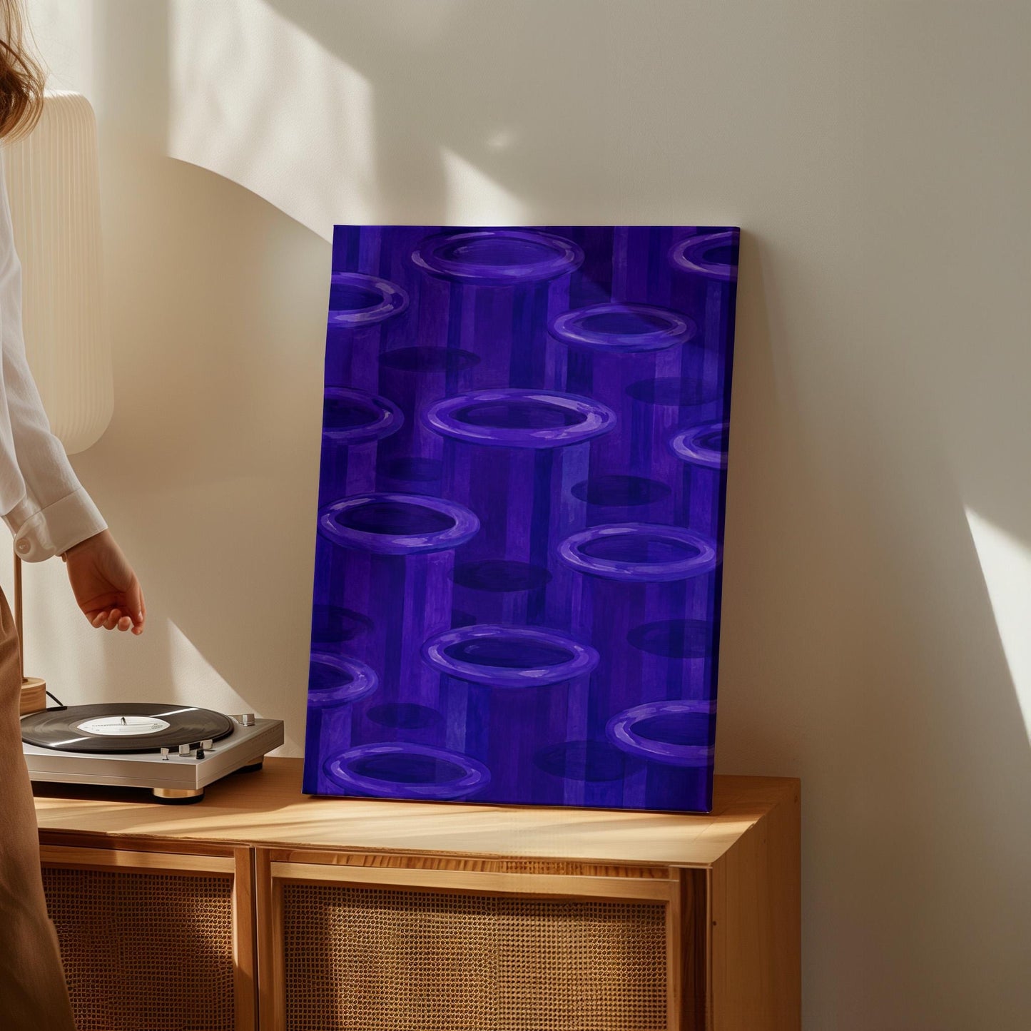 Rings emerging from deep violet and amethyst tones, canvas wall art hanging in a calm, modern living space