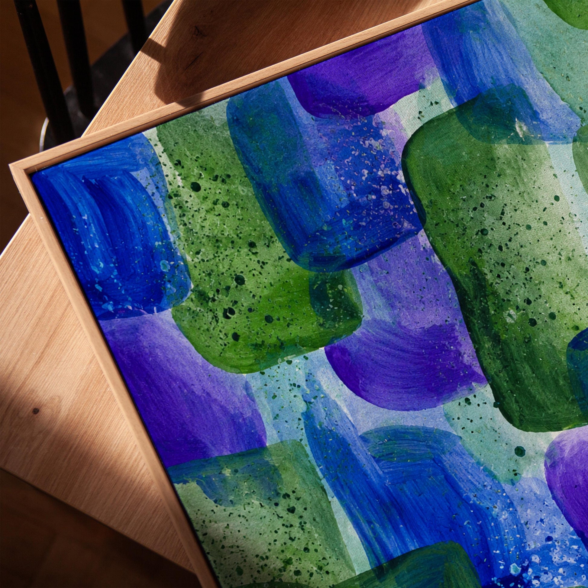 Painterly blocks in saturated blue purple and green, canvas print in a warm, minimally styled interior