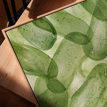 Interlaced looping rings in transparent greens, canvas print in a warm, minimally styled interior