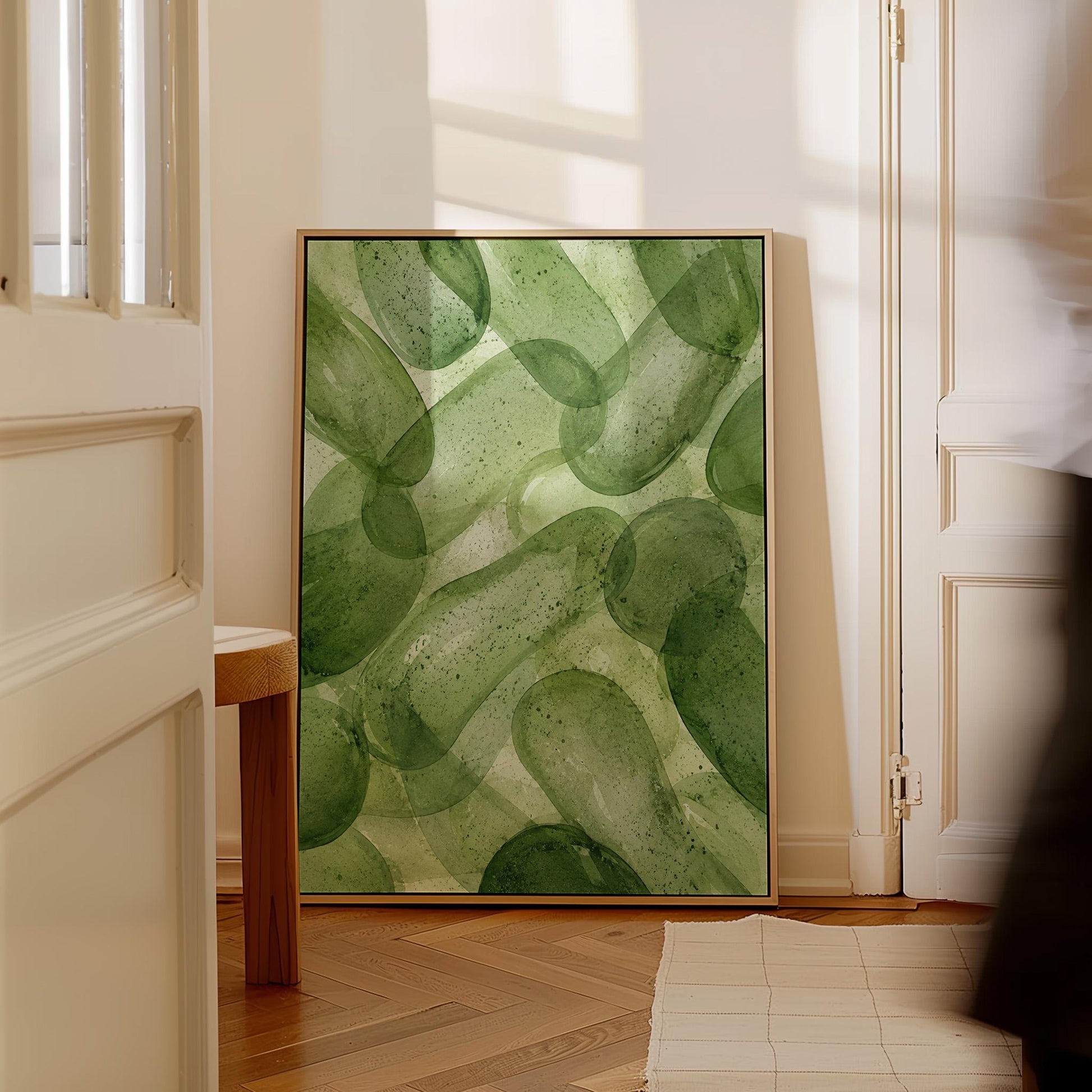 Interlaced looping rings in transparent greens, canvas wall art seen in a warm interior with natural light