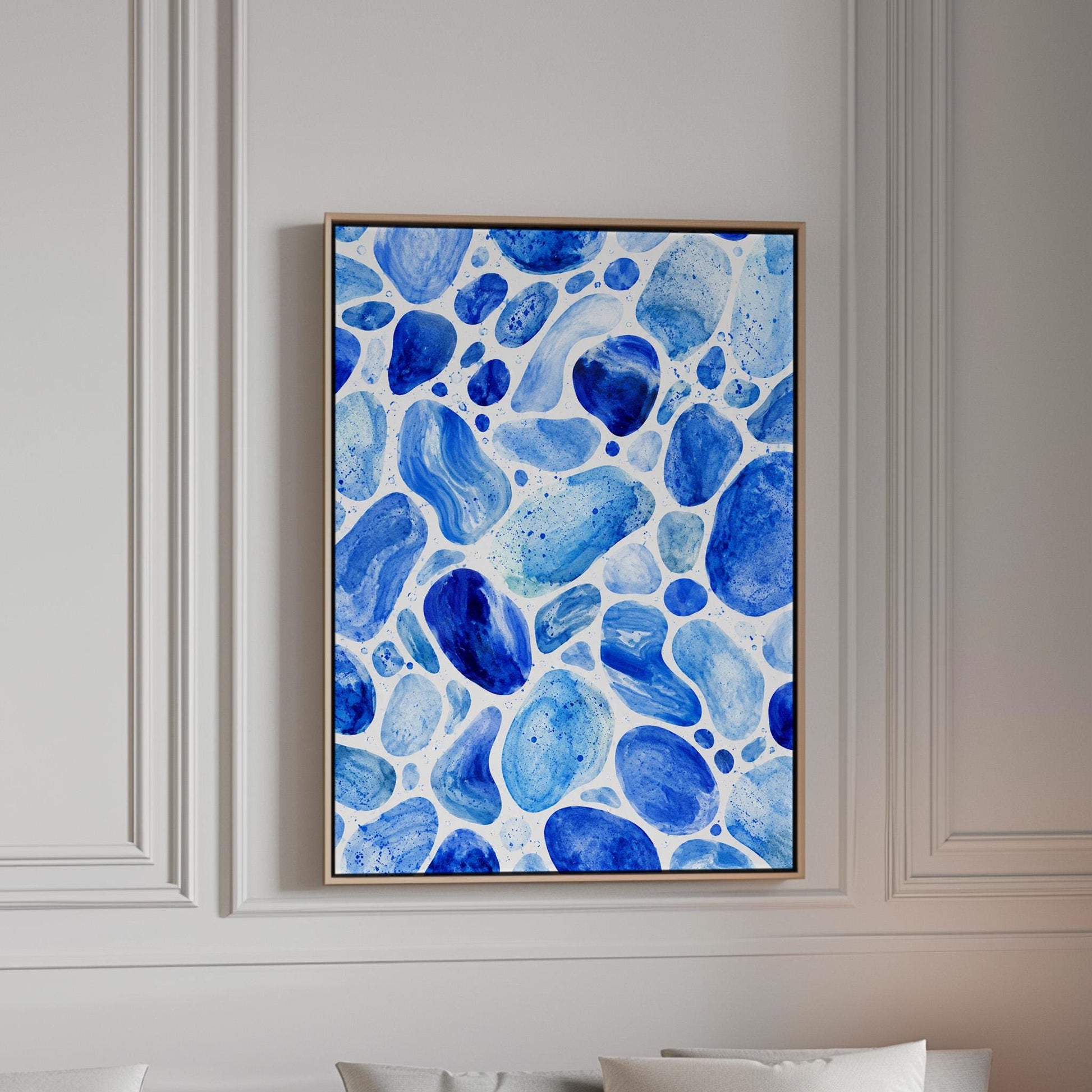Watercolor pebbles in shades of sky blue and cobalt, canvas print in a bright room with natural daylight