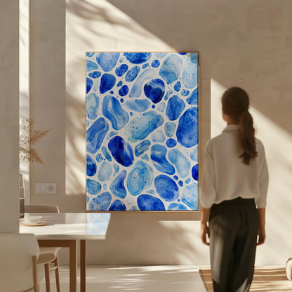 Watercolor pebbles in shades of sky blue and cobalt, canvas print hanging in a calm, modern living space