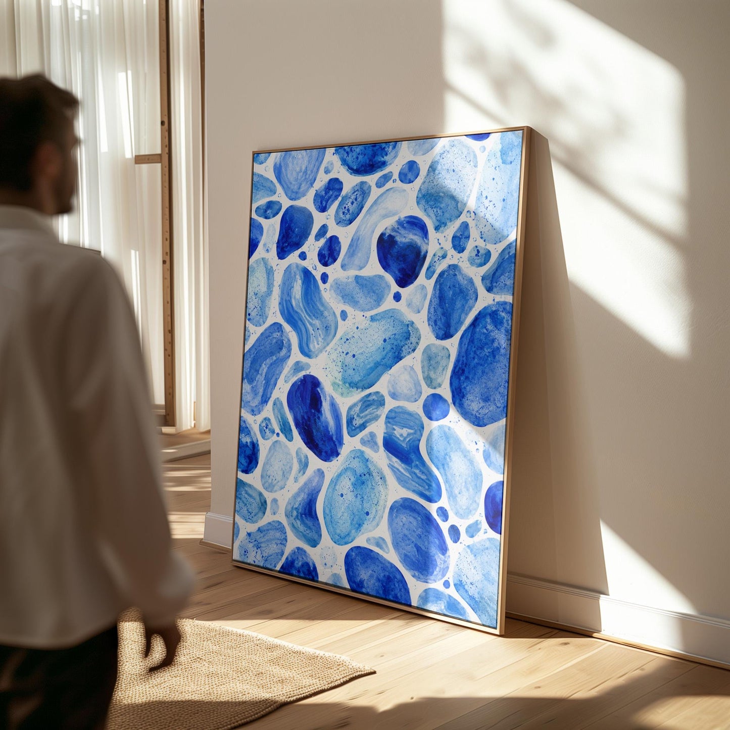 Watercolor pebbles in shades of sky blue and cobalt, canvas wall art hanging in a calm, modern living space