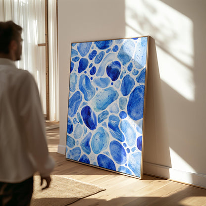 Watercolor pebbles in shades of sky blue and cobalt, canvas wall art hanging in a calm, modern living space