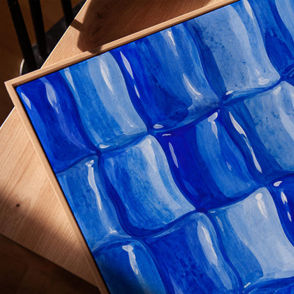 Grid of rounded squares in layered cobalt blues, canvas print in a warm, minimally styled interior