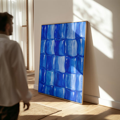 Grid of rounded squares in layered cobalt blues, canvas print seen in a warm interior with natural light