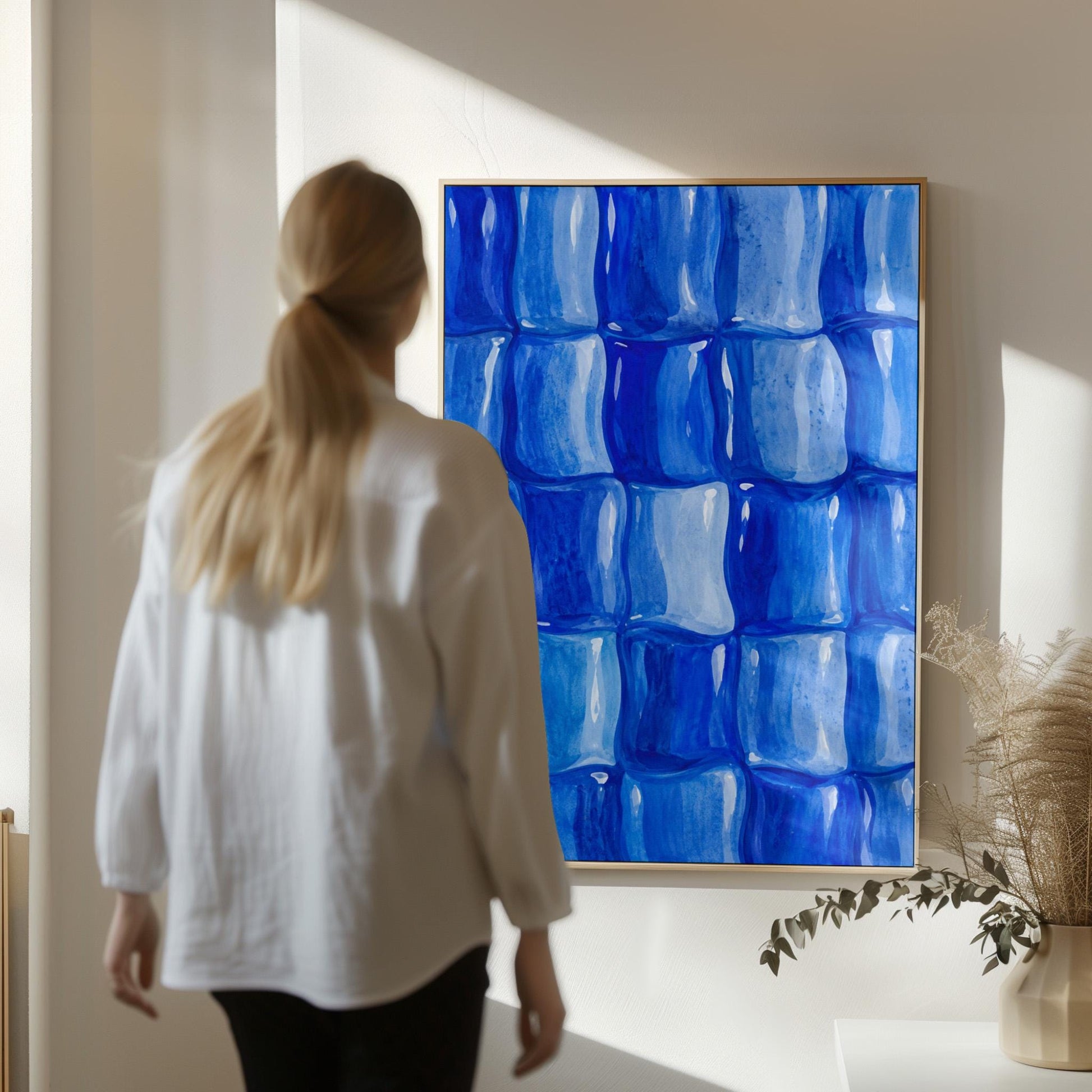 Grid of rounded squares in layered cobalt blues, canvas wall art hanging in a calm, modern living space